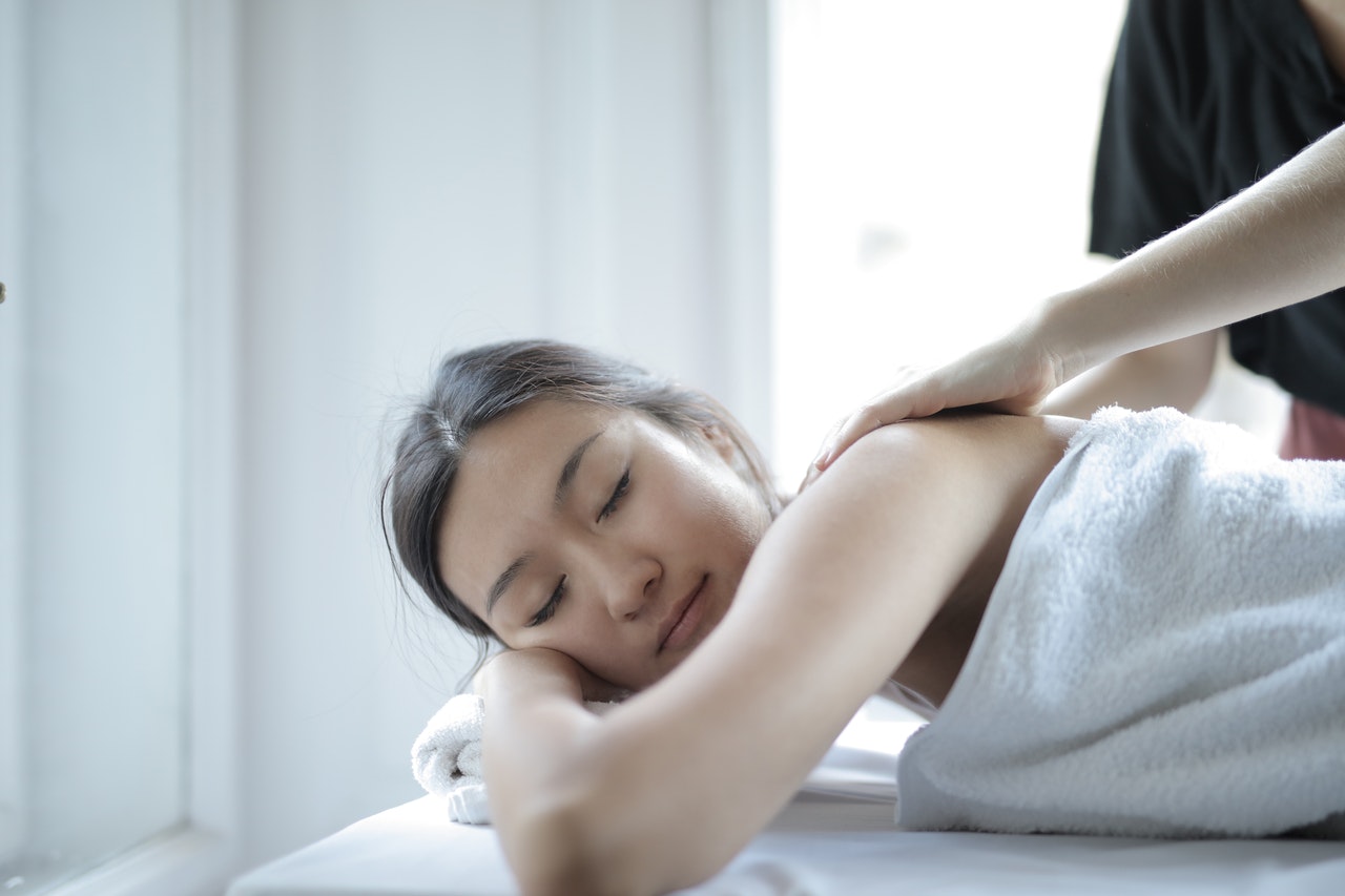 woman receiving massage on neck and shoulders